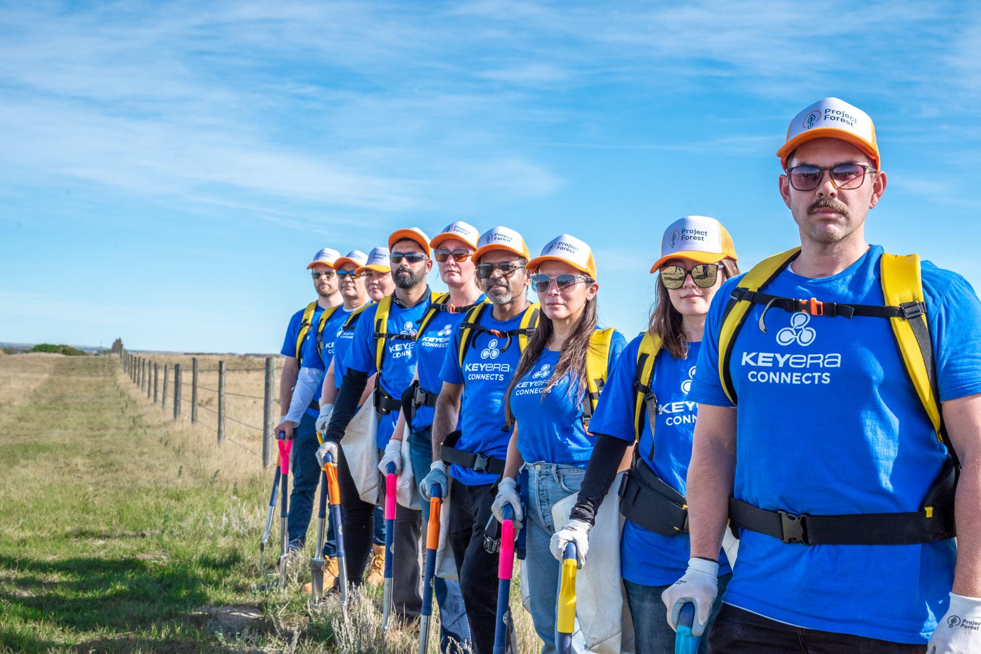 Group of volunteers in blue vests lined up outdoors