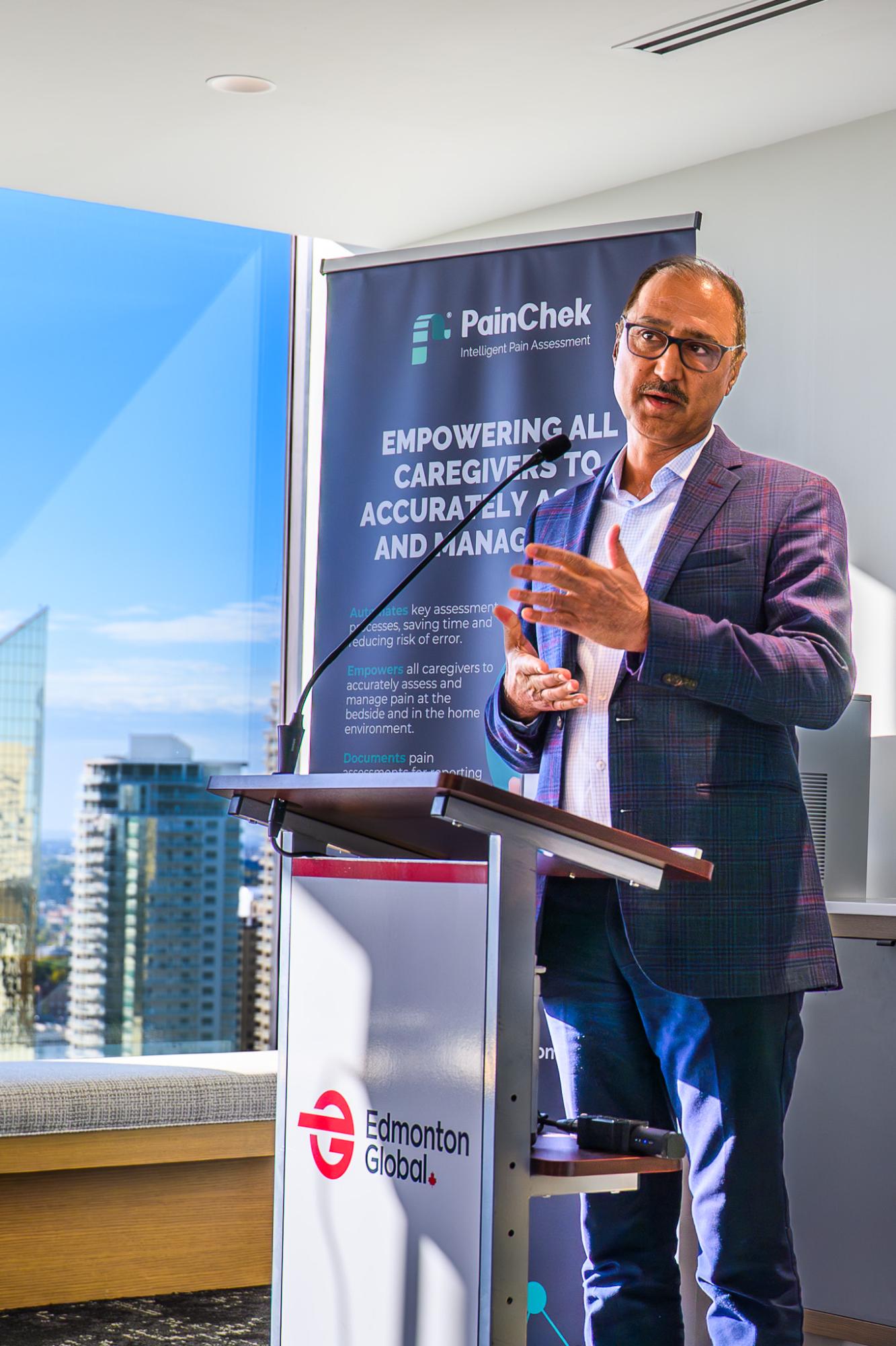 Man speaking at a podium at an outdoor corporate event